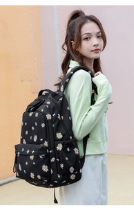 Detail of black canvas backpack with daisy floral print and front zipper pocket
