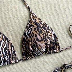 Detailed macro view of leopard print bikini top with triangle cups and adjustable drawstrings
