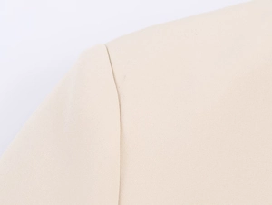 Makroaufnahme der beigen Blazer-Schulternaht mit hochwertiger Webstoff-Textur