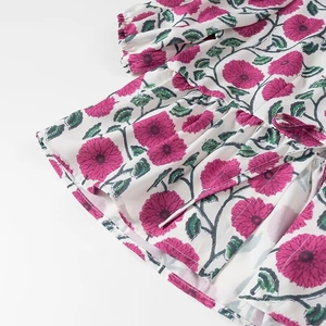 Détail du tissu à imprimé fleuri avec ourlet à volants et poignets élastiques blanc rose