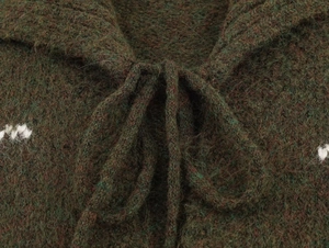 Close-up of olive green knit cardigan featuring fuzzy wool texture and embroidery ties
