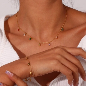 Close-up of model wearing gold stainless steel necklace and bracelet with colorful zircons