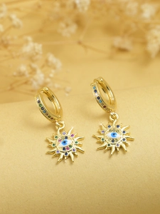 Close-up of golden sun-shaped evil eye earrings featuring colorful zircon stones and charms