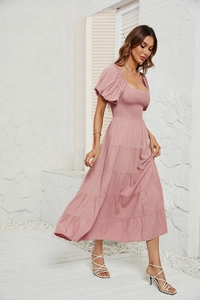 Gros plan sur les manches bouffantes roses et les détails du bustier d'une robe d'été