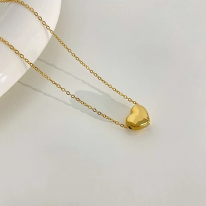 Collier minimaliste avec pendentif cœur en or 18k sur chaîne en O sur fond blanc