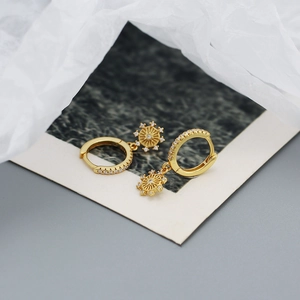 Detail of gold-plated 925 silver starburst earrings with sparkling cubic zirconia stones