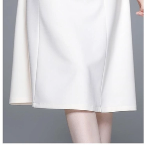 Détail de l'ourlet d'une robe blanche montrant la texture lisse et les coutures fines