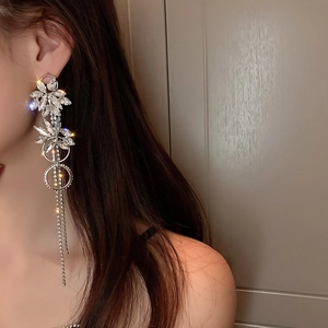 Silver needle flower tassel earrings with sparkling rhinestones worn on a model's ear