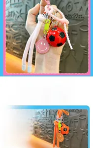 Macro detail of cartoon soccer keychain with smiley face tag and braided lanyard cord