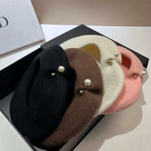 Detail view of four wool berets in black, coffee, beige, and pink with pearl accents