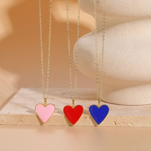 Close-up of pink red and blue enamel heart pendants on 14K gold plated necklaces