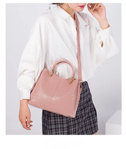 Close-up of pink crocodile pattern texture on stylish handbag with top handles