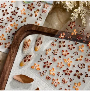 Nahaufnahme der Vintage-Nagelaufkleber mit Blumen- und Leopardmuster in herbstlichen Brauntönen