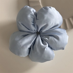 Detailed view of a light blue satin scrunchie with a 3D floral design on a white surface