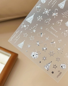 Detail of silver Christmas nail stickers with snowflake and bow patterns on model YT4366