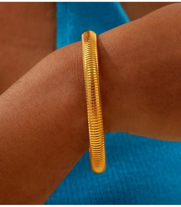 Macro shot of 18K gold-plated titanium steel bracelet with ribbed texture detail