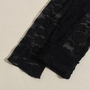 Dettaglio ravvicinato dell'intricato pizzo nero e della trama a rete della maglia