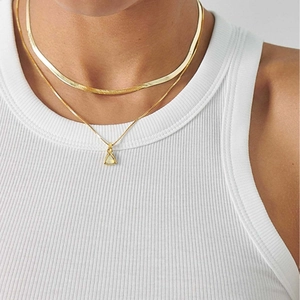 Gold stainless steel layered necklace featuring a minimalist triangle birthstone pendant