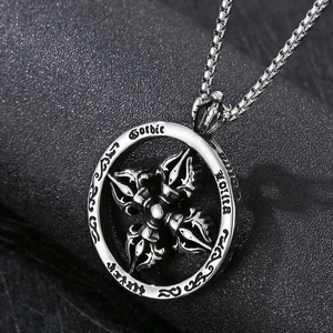 Detail of silver Gothic Talisman pendant with vajra cross design on black texture