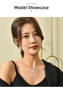 Elegant gold heart pendant necklace with shimmering crystals on model's neckline