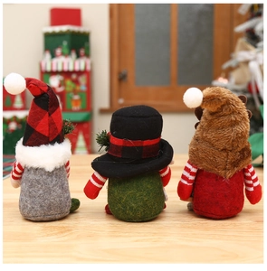 Detailed close-up of three handmade Christmas gnomes with plaid hats on wooden table