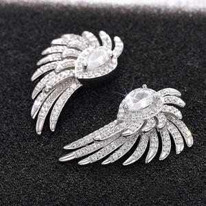 Macro shot of silver wing earrings with micro-paved cubic zirconia and pear-cut stone