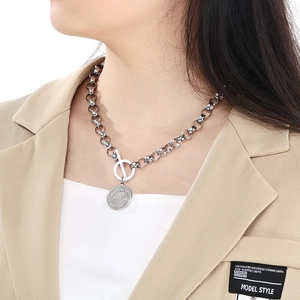 Détail du fermoir OT argenté et du pendentif gaufré sur un collier punk à grosses perles