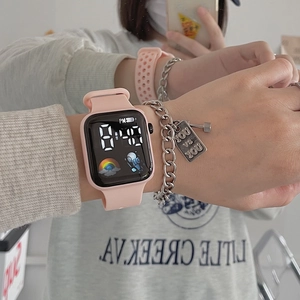 Pink silicone digital watch with black square LED display on wrist for daily lifestyle wear