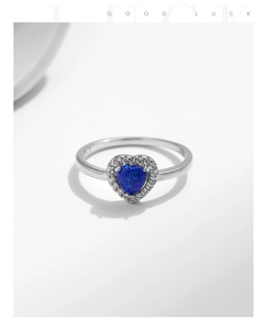 Macro shot of 925 silver heart ring with blue opal stone and clear zircon accents