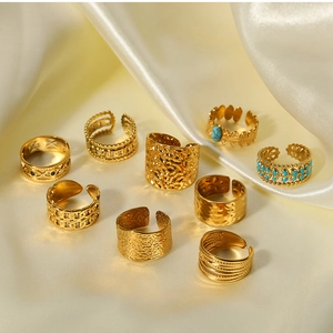 Detail shot of irregular 18k gold titanium steel rings on elegant cream silk fabric