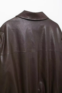 Detail view of the deep brown leather aviator jacket showing back and collar texture