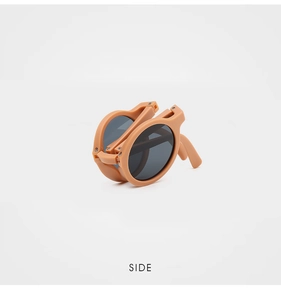 Detail of foldable kids sunglasses showing side hinge and matte apricot frame