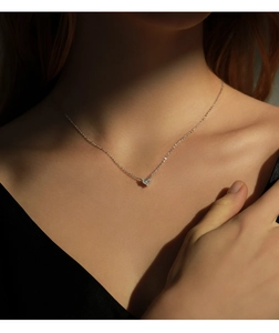 Close-up of S925 sterling silver heart necklace with sparkling diamonds on a model neck