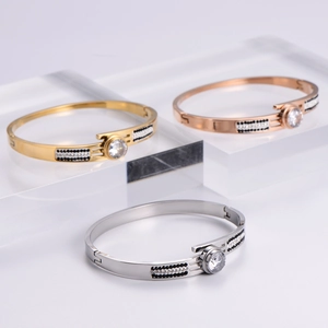Polished metal bangle bracelets with large round zircons and pavé accents in gold tones