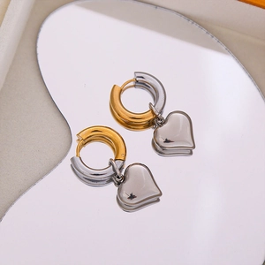 Two-tone heart drop earrings in gold and silver stainless steel on a mirror base