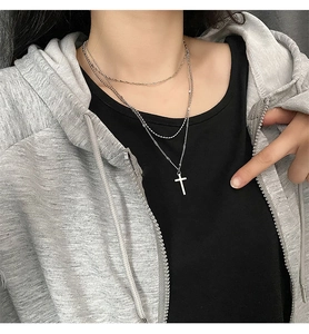 Detail of silver-tone double-layer cross pendant necklace with ball chain and fine link