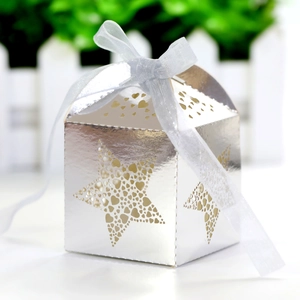 Macro shot of silver star gift box with laser-cut heart patterns and white ribbon bow