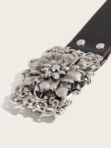 Detailed close-up of a black punk leather belt with an ornate silver floral buckle design