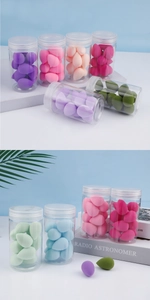 Macro shot of assorted colorful teardrop makeup sponges in a clear storage cylinder