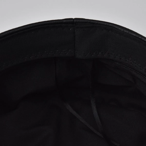 Close-up of black PU leather beret interior with cotton lining and adjustable ribbon