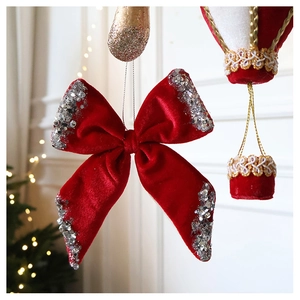 Close-up of red velvet Christmas bow with silver sequins and matching balloon ornament