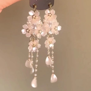Detail of pink floral tassel earrings with pearls and long dangling floral components