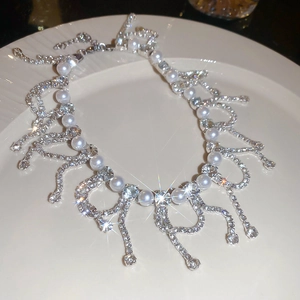 Detailed view of luxury pearl tassel necklace with sparkling rhinestones on silver base