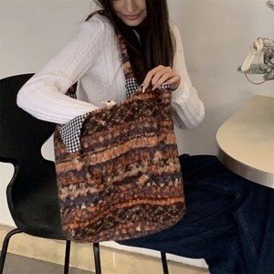 Close-up of bohemian knit tote bag with colorful wool weave and checkered lining