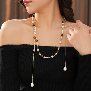 Detail view of double-layer pearl and tiger eye stone necklace with drop pearl charm