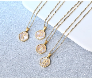 Macro view of gold stainless steel hexagonal shell pendants featuring letters I P D H