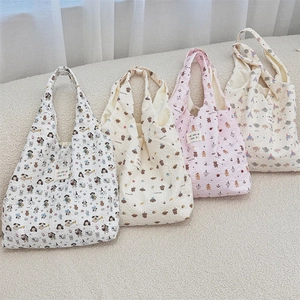 Detailed view of four quilted tote bags with cartoon dog and bear patterns on soft fleece