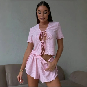 Pink two-piece loungewear set with hollow knit texture and tie-front short sleeve top