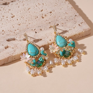 Macro detail of vintage floral drop earrings with turquoise, pearls and crystals on stone