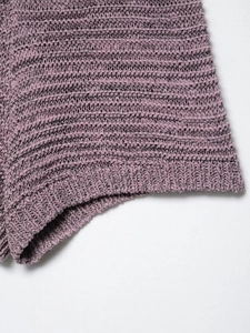 Detail of mauve knit top showing textured crochet pattern and ribbed hemline